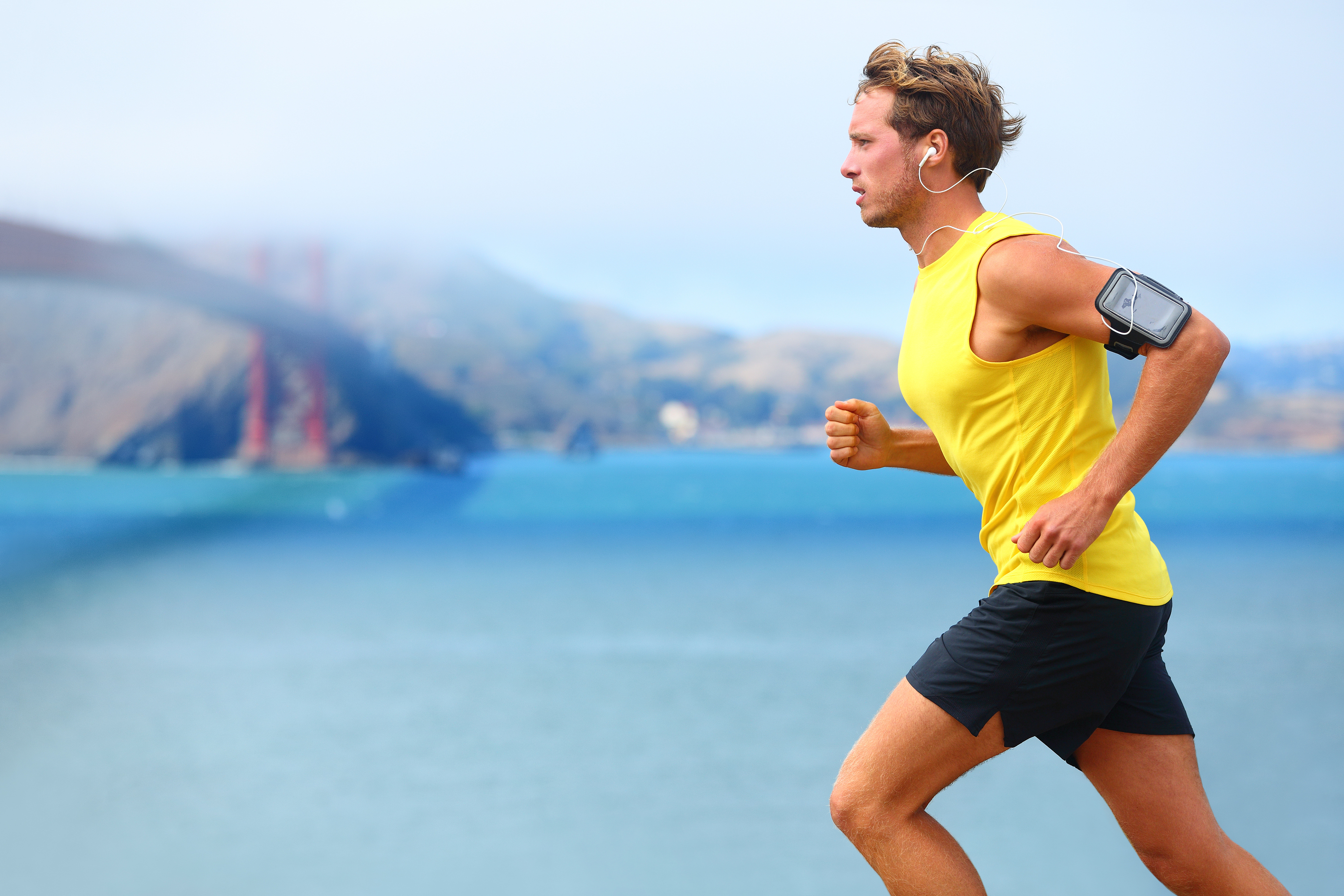 Athlete running man – male runner in San Francisco listening to